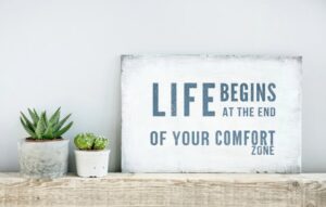 Life begins at the end of your comfort zone sign to help drum up courage. 